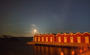 sjöbodar upplysta av fullmåne, knippla, november