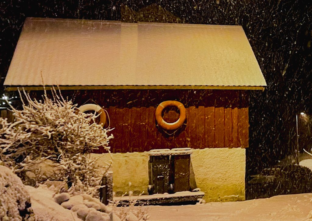 vintern kom till ön, snö. röd stuga, frälsarkransar
